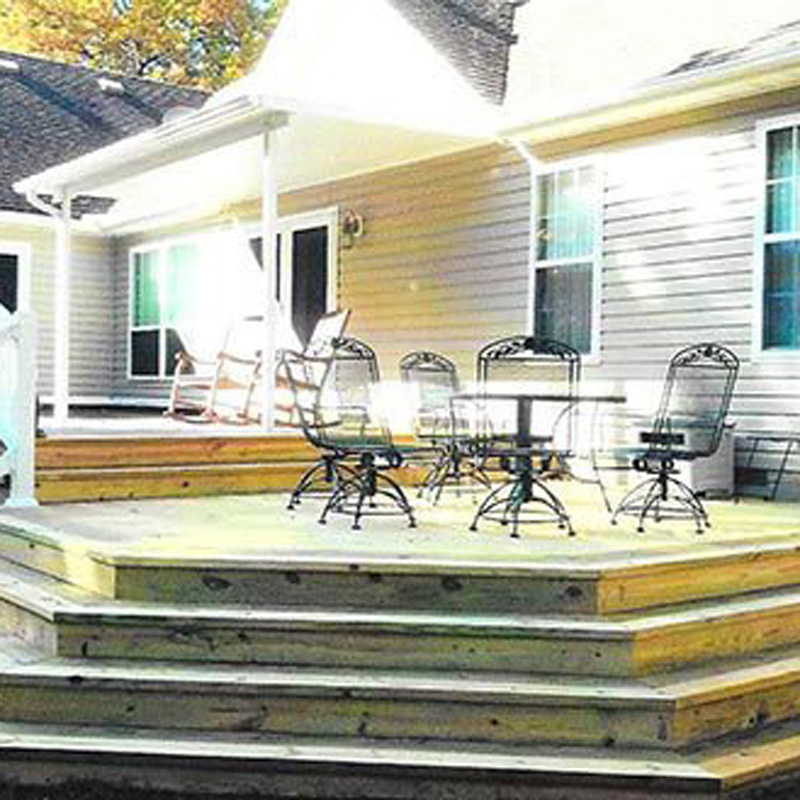 a newly constructed deck for a home with patio furniture on it